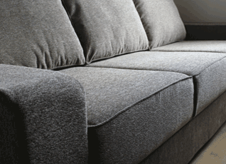 A sofa with piped cushions